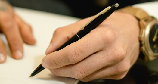 Closeup of Man's Hand Signing A Document