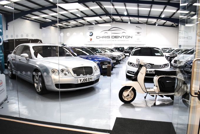 Car Showroom Filled With Cars and Scooter
